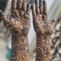 A closer look at an intricate design, showcasing the combination of swirls, paisleys, and shaded floral elements. The fingertips are fully covered, which gives a very traditional feel.