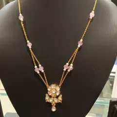 A delicate double-strand necklace with a floral Kundan pendant and soft pink beads. This is a perfect piece for a thoughtful gift or for adding a touch of elegance to your everyday style.