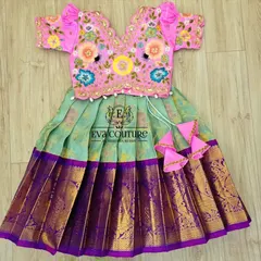 The beauty is in the details. This vibrant lehenga set features a pink blouse with intricate, multi-colored floral threadwork, paired with a light green skirt and a rich purple Kanchi silk border.