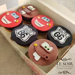 Kachow! These cupcakes were for a huge 'Cars' movie fan. I created fondant toppers featuring Lightning McQueen, Mater, and the iconic Route 66 sign. These are always a hit for kids' birthday parties.