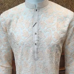A classic off-white kurta with delicate peach-colored paisley and floral threadwork. This is a timeless and elegant option for any daytime ceremony.