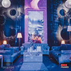 I designed this lounge area with plush blue velvet sofas and a mirrored coffee table. The backdrop is a mix of shimmering silver curtains and a custom graphic print, all framed by a glowing neon border.
