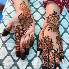 A view of both the front and back of the hands, showing how different patterns can be combined for a unique look. The palm features a traditional mandala while the back has a floral vine.