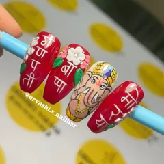 A closer look at the Ganpati nail art, showing the fine lines in the portrait and the delicate petals of the 3D flowers. Every element is carefully crafted to honor the festive spirit.