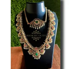 This layered bridal necklace set features a mix of pearls with red and green stones, giving you a colorful and royal look. The set includes a choker and a longer, more elaborate necklace to create a full bridal effect.