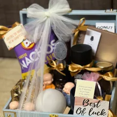 A farewell hamper packed in a stylish blue suitcase box and wrapped with a delicate white bow. The "Best of Luck" card adds a personal touch to the goodbye gift.