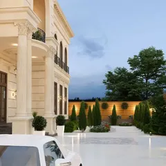 The driveway and entrance portico of the bungalow, showcasing the integration of landscaping and classical architectural columns.