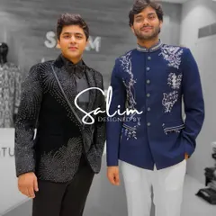 Two clients in contrasting styles. One wears a black tuxedo with cascading crystal work, while the other is in a blue Jodhpuri jacket with elegant white embroidery.