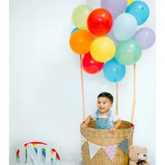 A full-length view of the whimsical hot air balloon setup for a first birthday. The colorful balloons and wicker basket create a perfect scene for a memorable solo portrait of the birthday boy.