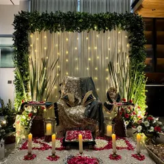We create serene and beautiful setups for Guru Ji satsangs. This particular design features a lush green floral frame, a backdrop of soft fairy lights, and carefully arranged rose petals on the floor, creating a peaceful and blessed atmosphere for prayer and meditation.