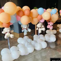 Adorable teddy bear centerpieces for a baby shower. These cute bears appear to be floating with balloon bouquets, adding a whimsical and charming touch to the guest tables.