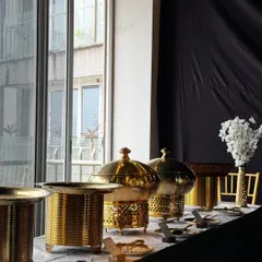 A close-up of our premium brass chafing dishes. The intricate design and polished finish of our serveware add a level of sophistication and luxury to the buffet table.