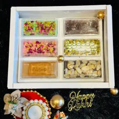 An elegant Rakhi gift box featuring an assortment of our fusion chocolate barks. Flavors include rose pistachio, biscoff, and various nut and seed combinations.