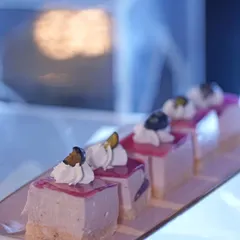 Our Blueberry Cheesecake is a modern classic. These individual portions feature a creamy cheesecake filling on a biscuit base, topped with a sweet blueberry compote and a dollop of whipped cream.