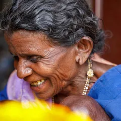 A close-up portrait capturing a soft, downward glance. The focus is on the 'aaji's' expression, filled with a gentle warmth that makes this image incredibly touching and real.