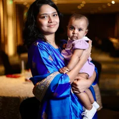 A lovely portrait of a mother and her baby. The rich color of her dress and the baby's curious expression make this a memorable shot.