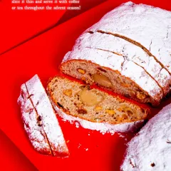 A slice of our traditional German Stollen, a dense, buttery bread studded with rum-soaked fruits, nuts, and a marzipan core.