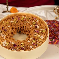 My legendary Paneer Ghewar, a true Rajasthani delicacy. This disc of sweetness is crafted with a crunchy, porous texture and loaded with rich paneer and nuts, making it a festive centrepiece.