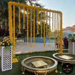 Here is another view of the marigold curtain backdrop, now showing the traditional brass urlis and painted chowkis ready for the Haldi ceremony. This poolside decoration combines traditional elements with a beautiful natural setting.