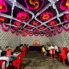 A beautiful pandal ceiling decorated with pink, orange, and white drapes for a Ganpati festival celebration. This kind of intricate ceiling work makes the pandal feel grand.