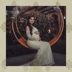 A stunning maternity photoshoot featuring a custom-designed white lace gown. The off-shoulder design and long train create a look of ethereal beauty.