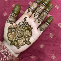 A beautiful floral bunch placed on the back of the hand, with detailed leaves and petals. The fingers are decorated with matching bands.