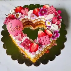 A heart-shaped monogram tart I made for Valentine's Day. It's loaded with fresh strawberries, pink chocolates, marshmallows, and edible flowers.