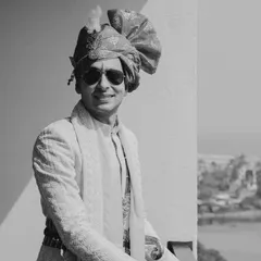 A classic black and white portrait of the groom on his wedding day. The traditional safa and textured sherwani create a look of timeless elegance, captured beautifully in this shot.