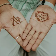 Minimalist groom henna doesn't have to be boring. This design features a simple, elegant initial on one palm and the couple's names in a heart on the other. It's a beautiful, understated way to celebrate your connection.