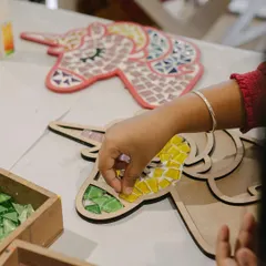 Planning an art party is easy with us! This young artist is making a unicorn mosaic, one of the many activities you can choose for a birthday celebration. We offer a wide range of crafts to fit any theme.