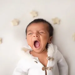 A great big yawn from this tiny baby in his cozy white outfit. Newborn yawns are one of the most adorable and fleeting moments to capture.