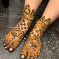 This bridal leg design features architectural domes and elephants, mirroring the patterns on the bride's hands for a cohesive look.