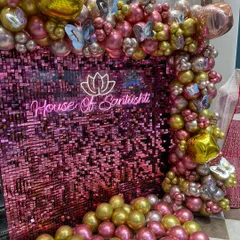 Another angle of the 'House Of Santushti' brand launch decor. This view highlights the integration of the neon sign within the pink sequin backdrop and the lush, multi-layered balloon garland, which includes butterfly foil accents for a touch of elegance.