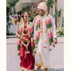 A joyful walk together after the ceremony, hand in hand. The bride's radiant smile and the groom's happy glance perfectly capture the bliss of a South Indian wedding celebration.