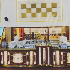 A wide view of our elegant buffet and menu counter setup in a spacious hall. The gold and white theme creates a look of timeless luxury.
