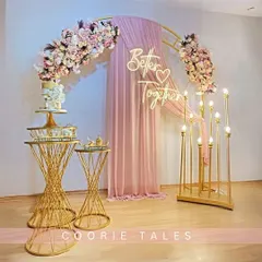 Celebrating that you're "Better Together" with this romantic setup. It features a golden arch, soft pink draping, a custom neon sign, and elegant floral arrangements, creating the perfect photo-ready moment for an engagement or anniversary.