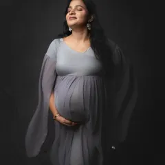 Serenity in shades of grey. The soft, flowing fabric of this gown adds a dreamy, ethereal quality to this moody and emotional solo maternity portrait.