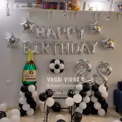A classic and elegant setup for a 28th birthday. We used black, white, and silver balloons with star accents and a large champagne bottle foil balloon to create a sophisticated party corner.