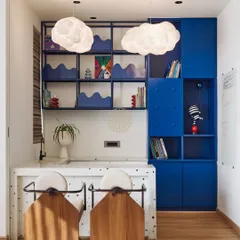 This activity area was designed to inspire play. It includes a counter for games, Lego-inspired blue storage for artwork, and whimsical cloud-shaped pendant lights.