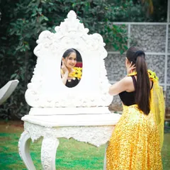 A creative pose from a photoshoot. The makeup is kept fresh and glowing to complement the vibrant yellow outfit, while the sleek ponytail adds a touch of modern elegance.