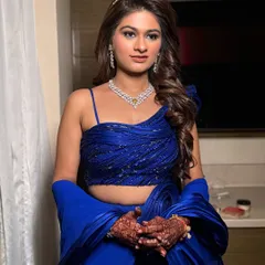 The full look, showcasing the stunning blue lehenga and the confident pose of my bride. The hair is styled in soft waves to balance the drama of the makeup and outfit.