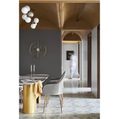 A closer look at the dining nook, where the high vaulted ceiling in semi-circular arches makes a statement. The deep grey wall, orb lighting, and custom furniture come together to create a classy, intimate setting for meals.