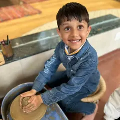 The pure joy of creation. This young boy's smile says it all as he masters the basics of the potter's wheel, a truly empowering and fun experience for kids.