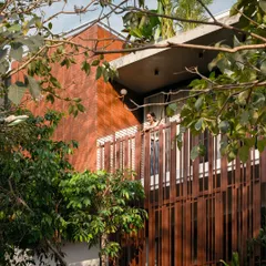 Peeking through the trees, the home's brick and metal facade feels integrated with the natural environment, showcasing our belief that architecture should complement, not dominate, nature.