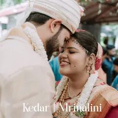 A tender moment from a wedding ceremony, with the groom kissing the bride's forehead.