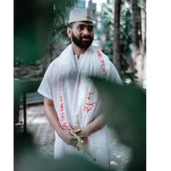 A candid shot of the groom during his Haldi ceremony, captured through foliage.