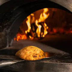 Embrace the taste of tradition with my freshly baked Ciabatta Bread, emerging golden and puffy from the wood-fired oven.