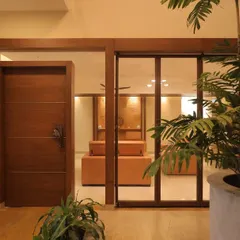 The entrance to the Ekta Residence living area, viewed from the courtyard. We used a combination of glass partitions and solid wood doors to create a layered, transitional space that feels both open and private.