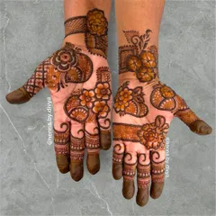 A vibrant and full floral mehendi design. This pattern combines different flower shapes and sizes with paisley elements, creating a rich and organic look that covers the entire palm.