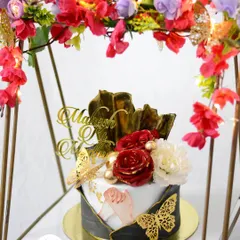 A close-up of the engagement cake hamper. The cake features intricate details like golden butterflies, delicate flowers, and a custom cake topper, making it a complete gift for the special day.
